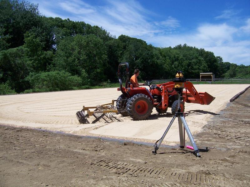 tractor spreading sand for foundation